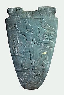 https://upload.media.orgikipedia/commons/thumb/e/e3/Narmer_Palette_smiting_side.jpg/220px-Narmer_Palette_smiting_side.jpg
